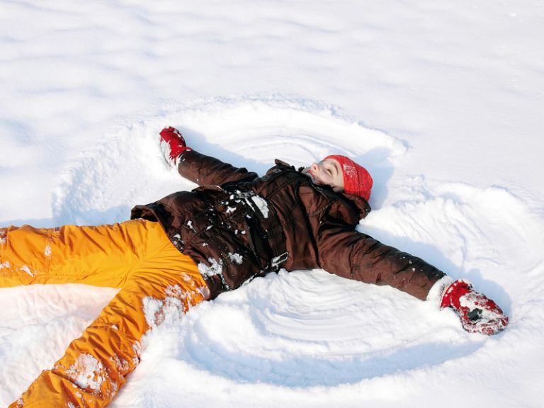 Kind macht Schneeengel